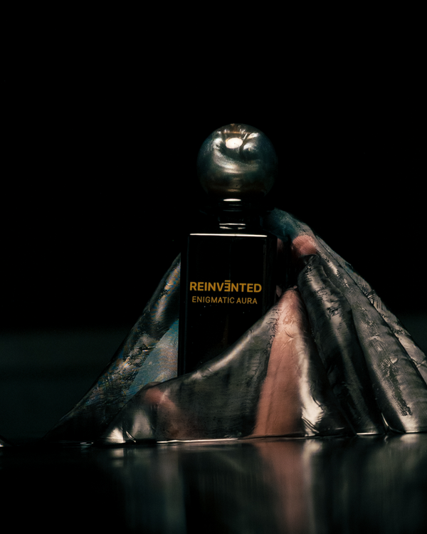 Perfume bottle labeled 'Reinvented Enigmatic Aura' with a dark background