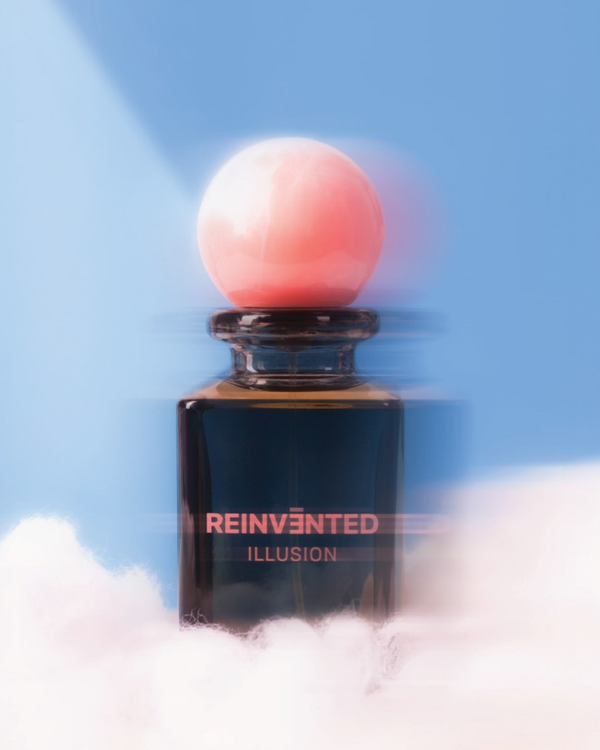 Perfume bottle labeled 'Reinvented Illusion' with a pink sphere on a blue background